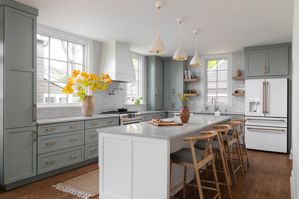 Bright kitchen with a white island, pendant lighting, gray cabinets, and natural wood accents in an Ann Arbor, MI home renovation.