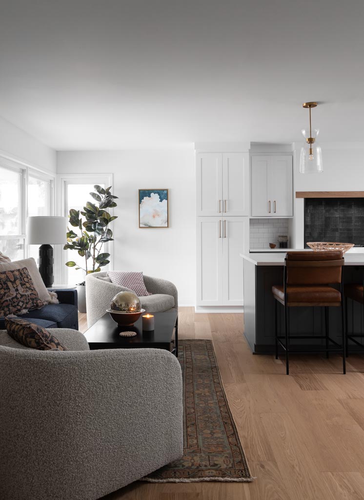  Modern open-concept kitchen in Plymouth, MI, featuring a spacious island, natural wood flooring, and seamless flow into the dining and living areas.