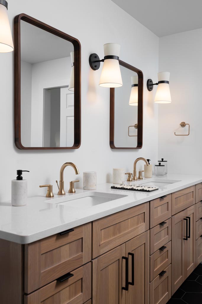 Primary spa-like bathroom featuring natural textures such as a white oak vanity, freestanding tub, and brass fixtures, with soft green accents for a serene retreat.