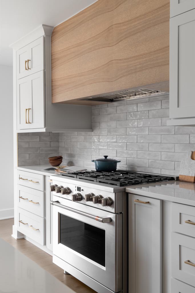 Custom white kitchen cabinetry with clean lines, brass hardware, and a modern design in Plymouth, MI. High-End Kitchen Remodel Ideas