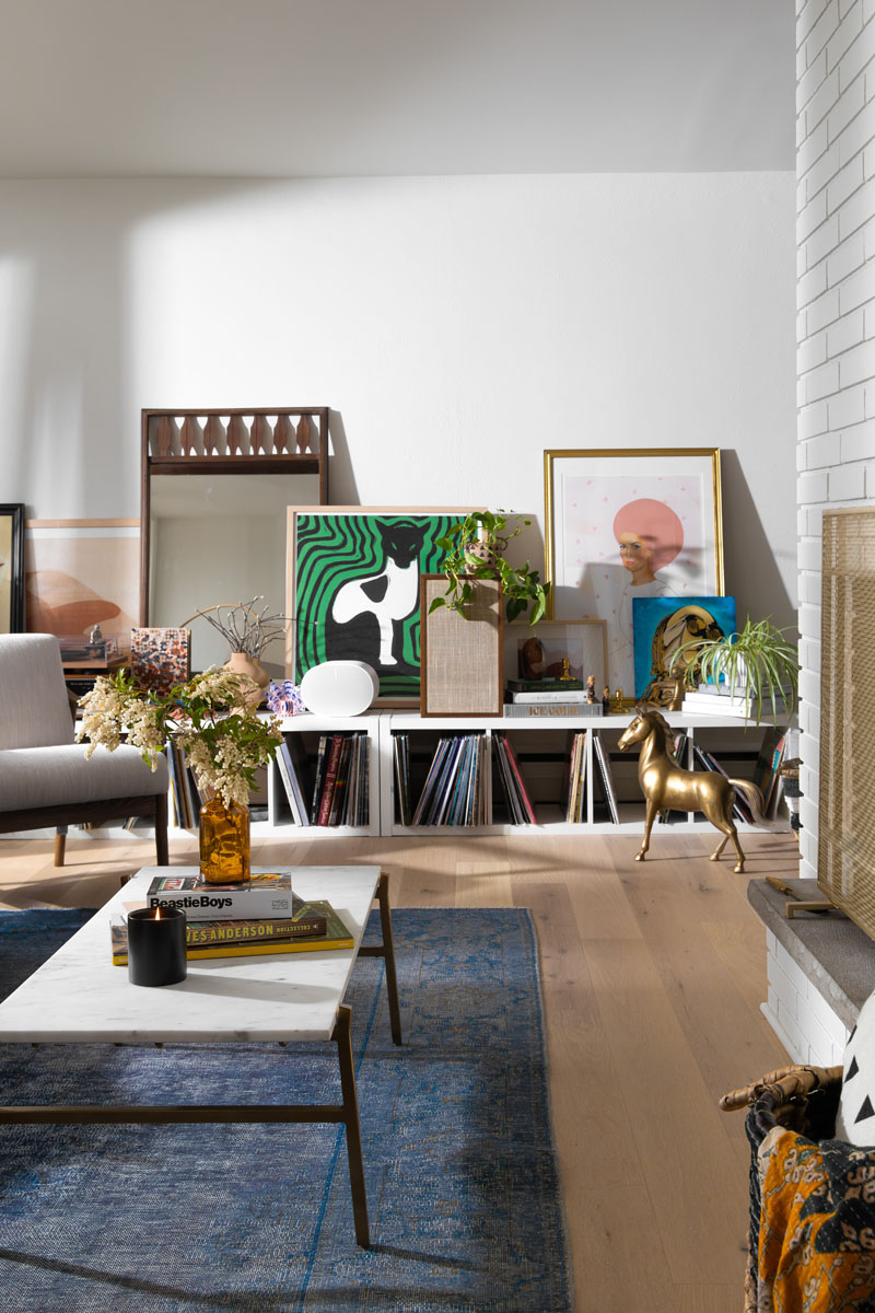 Custom shelving in Royal Oak, MI, with bold green and pink artwork, modern decor, and eclectic accents.