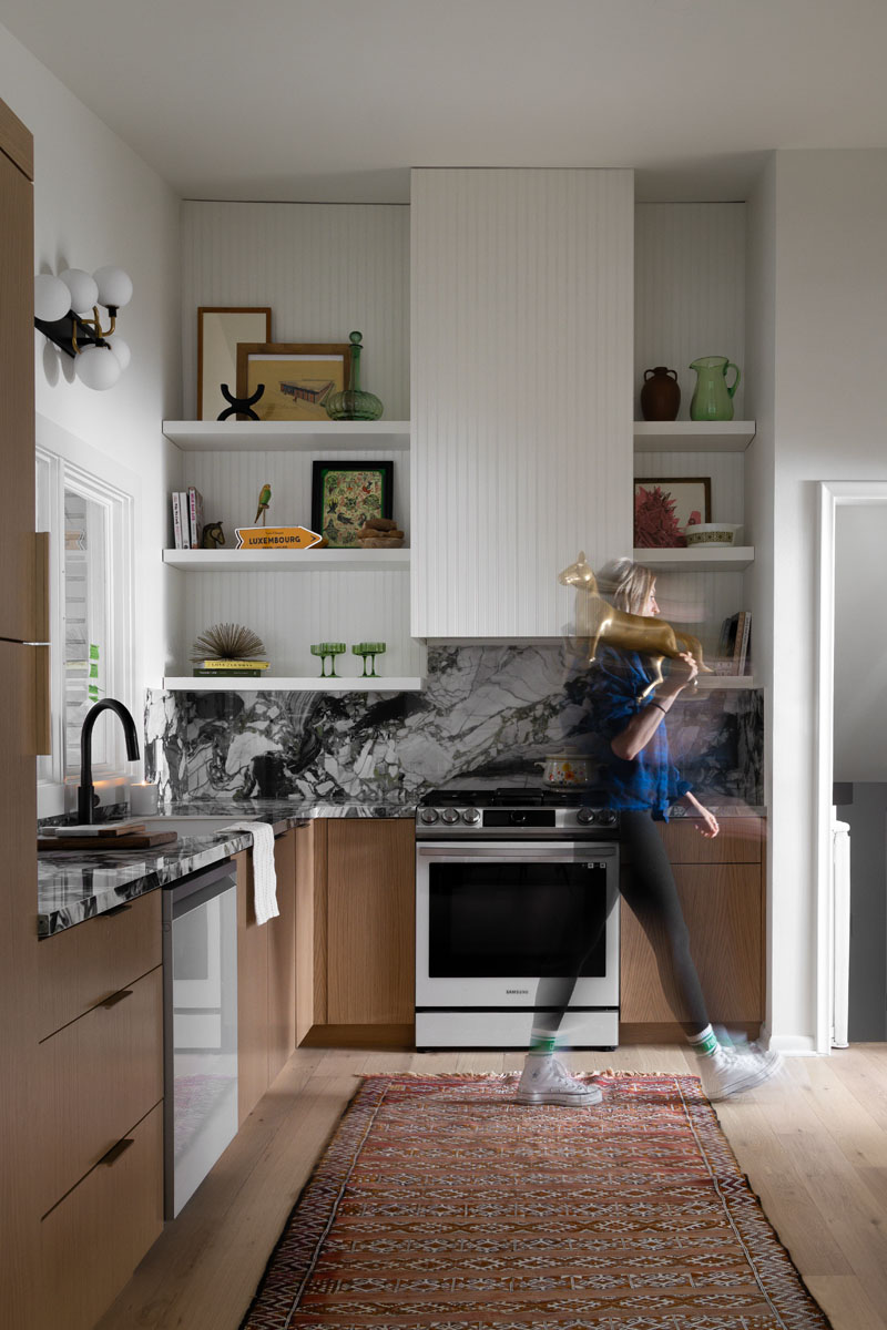 Luxury kitchen in Royal Oak, MI, showcasing open shelving with curated decor, marble accents, and a clean, modern aesthetic.