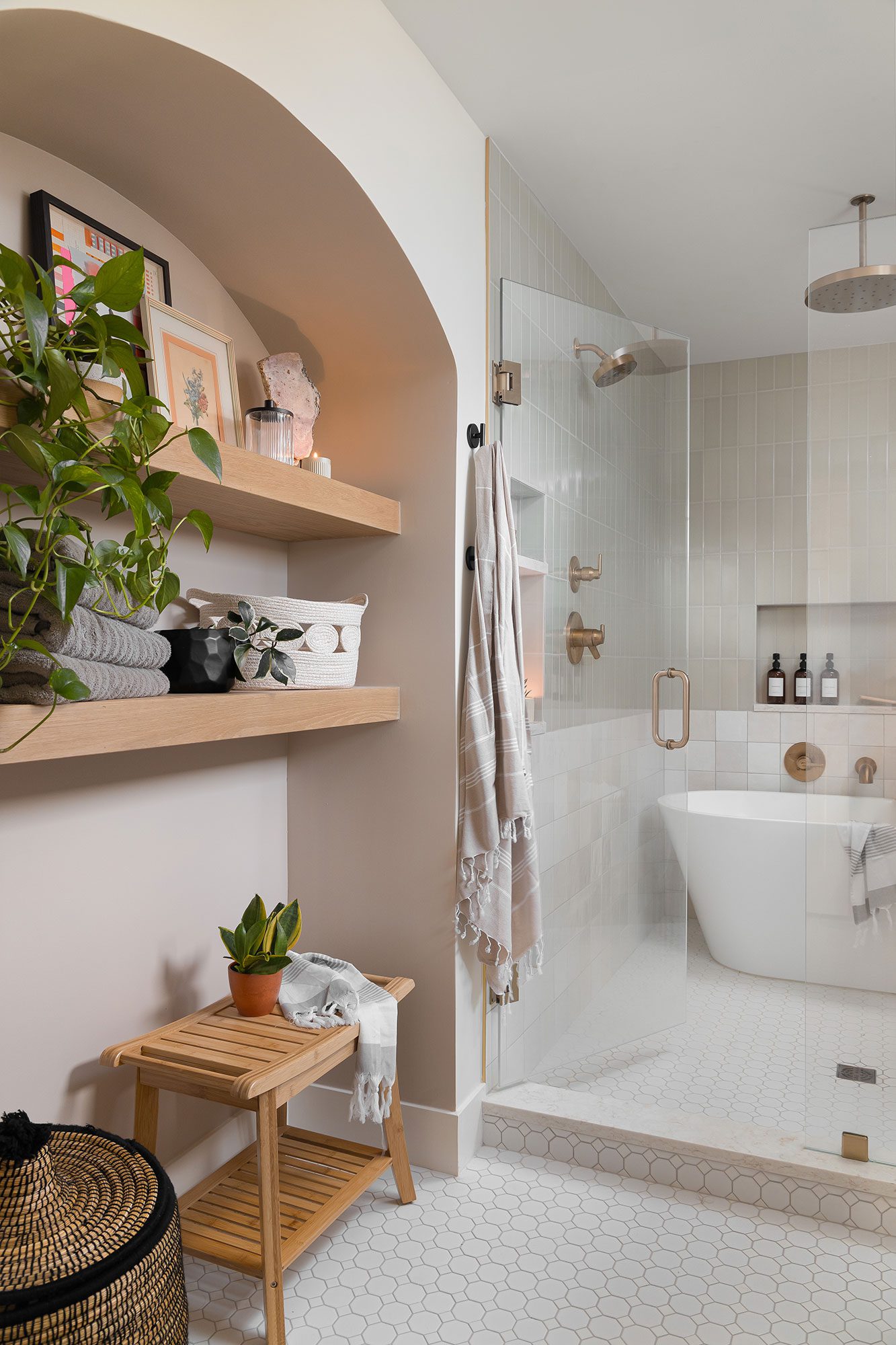 Michigan lake house bathroom with spa-like features, including soft green walls, brass fixtures, and a white oak vanity.