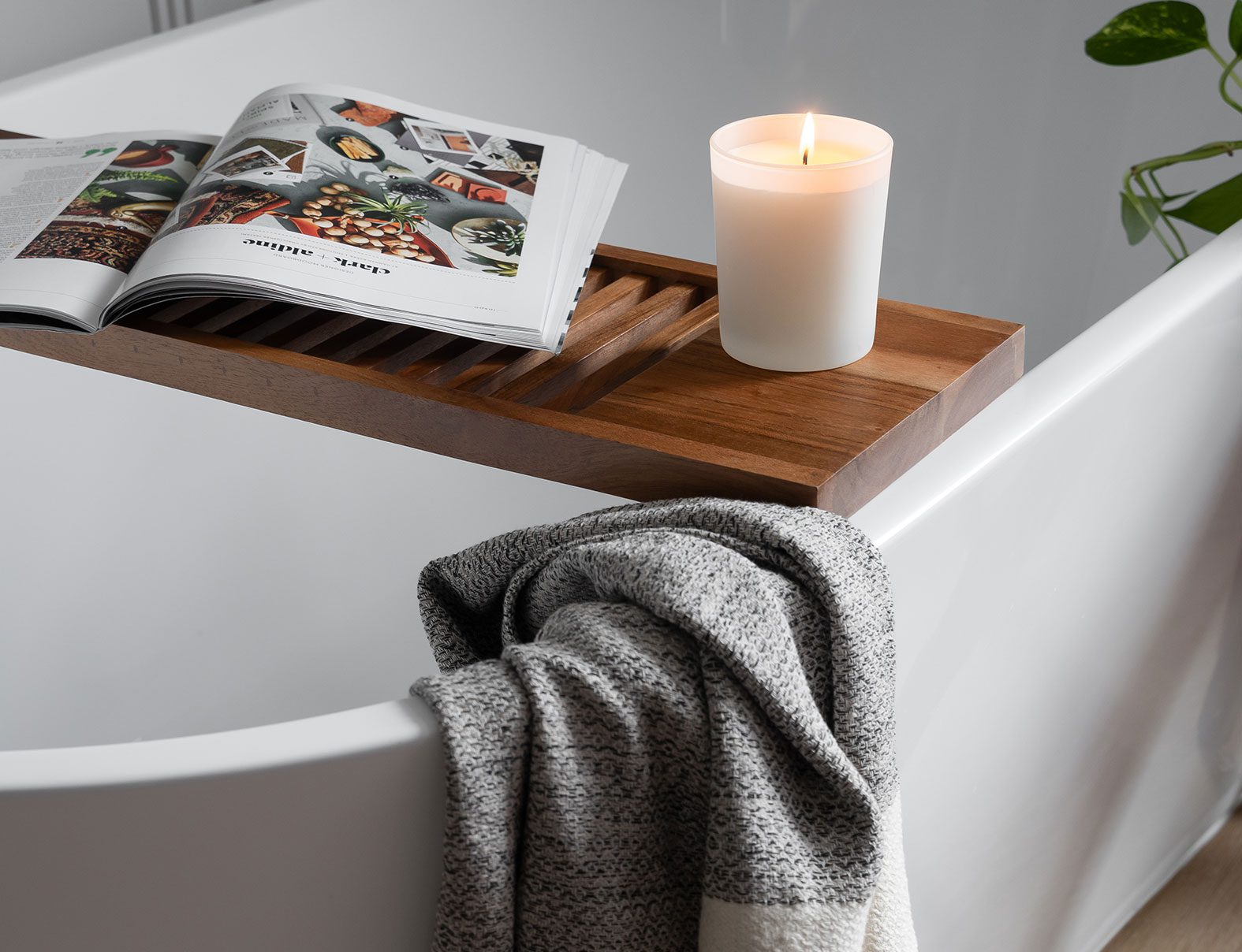 Residential interior design by Clark + Aldine – a modern bathroom tub styled with carefully curated finishing touches.