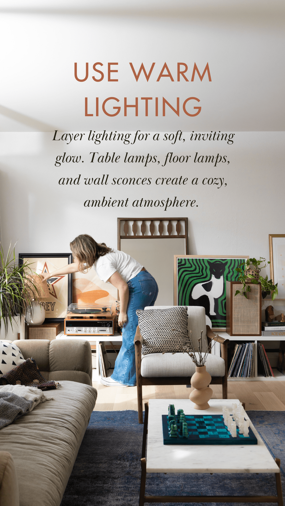 A living room with layered warm lighting, featuring table lamps, wall sconces, and natural light for a cozy, biophilic atmosphere. Designed to promote relaxation and connection.