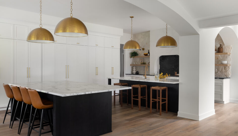 High-end kitchen in Plymouth, MI, featuring custom white cabinetry, quartzite countertops, brass pendant lighting, and a spacious island.