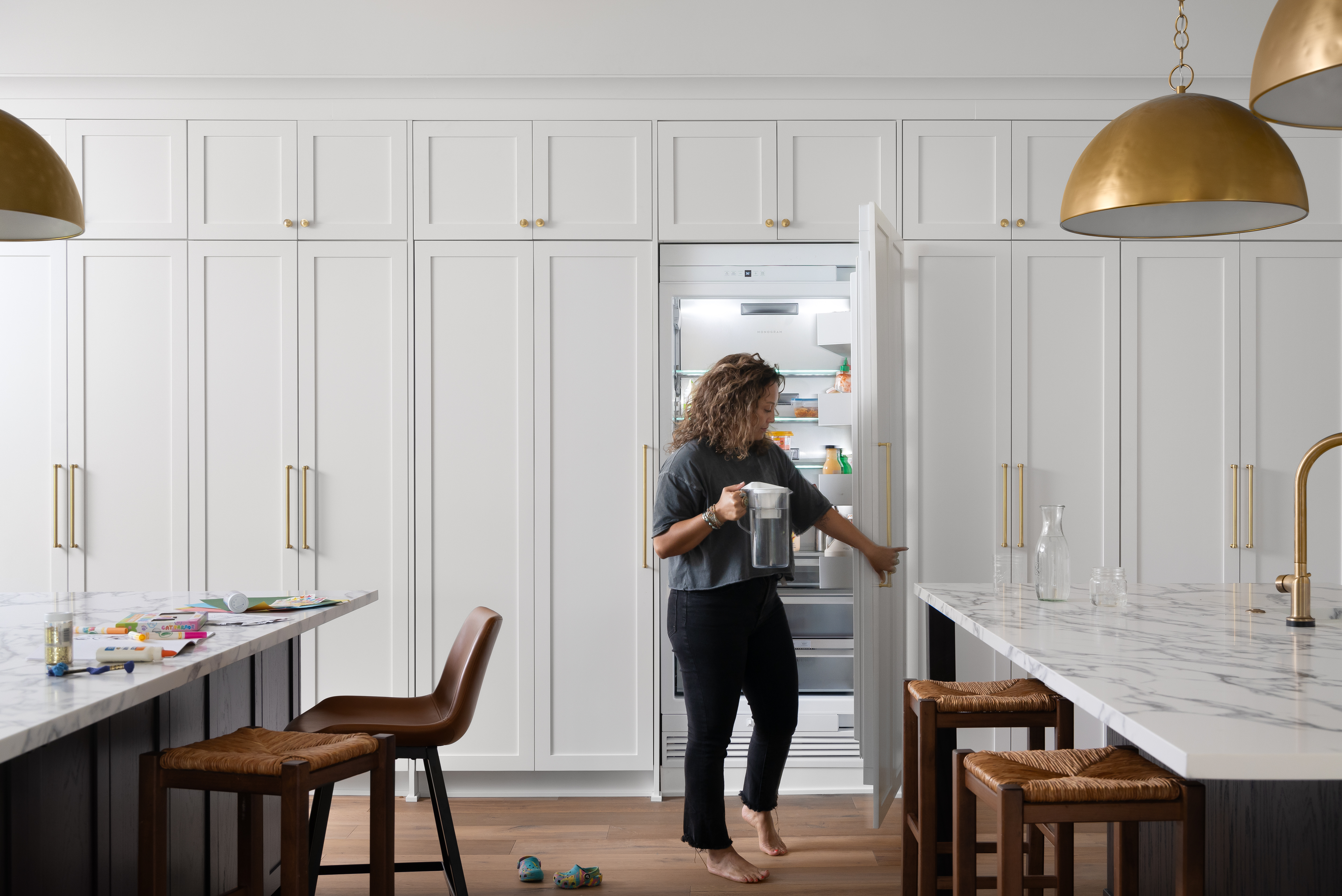 Modern kitchen in Plymouth, MI, featuring hidden appliances, custom white cabinetry, and a minimalist aesthetic.